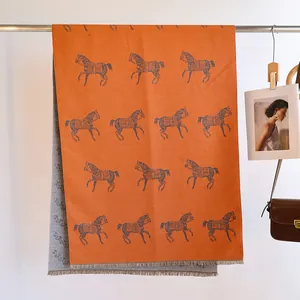 Close-up of double-sided horse jacquard scarf with orange and grey cashmere-like fringe