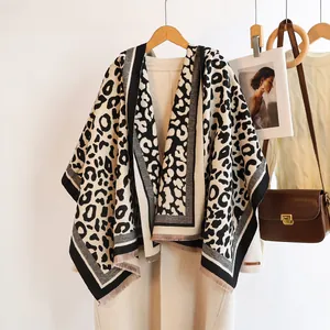 Cozy thick leopard print scarf with fringe tassels worn over a beige coat for winter