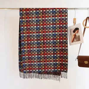 Detail of colorful plaid scarf with soft fringe texture hanging in a fashion boutique