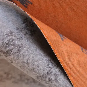 Macro detail of double-sided jacquard scarf with orange pattern and reinforced edges