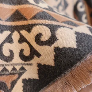 Close-up of jacquard horse pattern and fringe detail on soft cashmere feel scarf