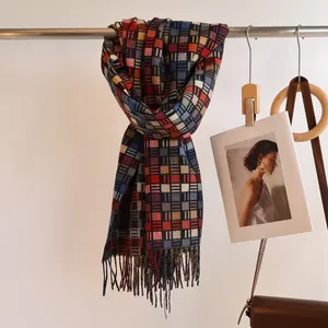 Detail of colorful plaid scarf with soft fringe edges hanging in a boutique setting