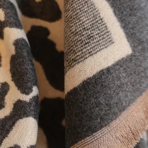 Close-up of thick leopard print scarf showing detailed knit texture and fringe edge