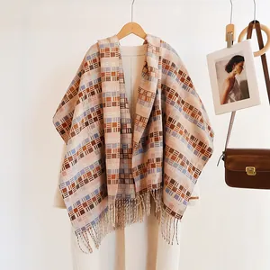 Detail of plaid winter scarf with fringe paired on beige coat for an elegant look