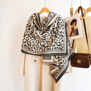 Detail of leopard print scarf with fringe edges and handmade label on wool coat