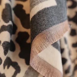 Detailed close-up of soft cashmere-feel leopard print scarf featuring fine fringe edges