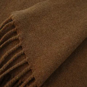 Close-up of caramel wool scarf showing soft texture, fine fibers and tassel fringe details