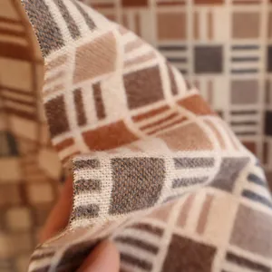 Close-up of soft plaid winter scarf showing thick flannel texture and tassel details