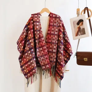 Detail of reddish-brown plaid scarf with long tassels and a handmade leather label