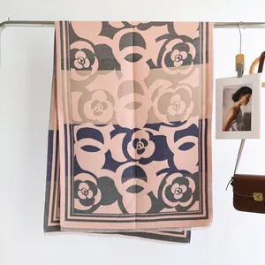 Detail of camellia print cashmere-like shawl with elegant color blocking and fringe edges