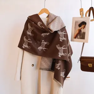 Close-up of double-sided horse jacquard scarf with fringe and handmade label detail