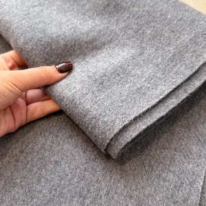 Close-up of thick grey wool fabric texture showing the soft fringe detail and material density