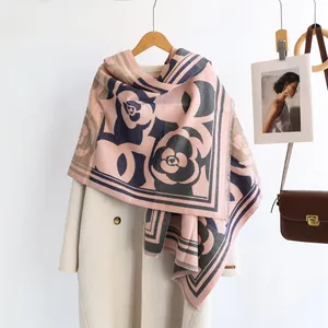 Detail of pink cashmere-feel scarf featuring camellia floral patterns and border