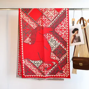 Detail of red cashmere scarf with jacquard horse print and baroque border patterns