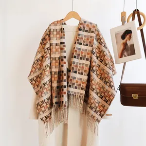 Detail of warm winter scarf with brown geometric plaid pattern and long tassel trim