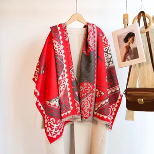 Detail of red and grey ethnic jacquard scarf with decorative fringe on a white coat