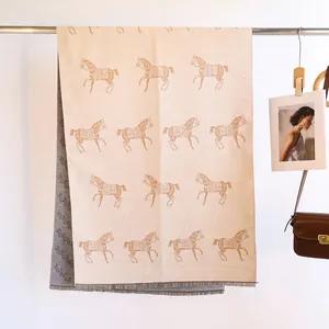 Close-up of double-sided horse jacquard cashmere scarf with fringe hem detail