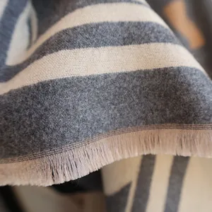 Detail shot of soft cashmere-feel striped scarf with elegant fringe edges and soft texture