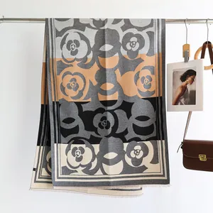 Detail of camellia pattern scarf with fringe and contrast color block texture