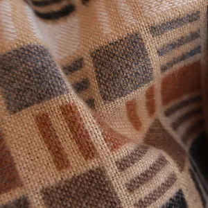 Close-up of thick plaid winter scarf fabric showing soft cashmere-like weave and texture