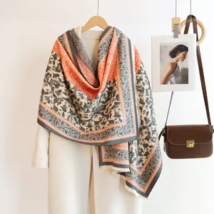 Close-up of paisley print cashmere-like scarf with fringe details and thick warm texture