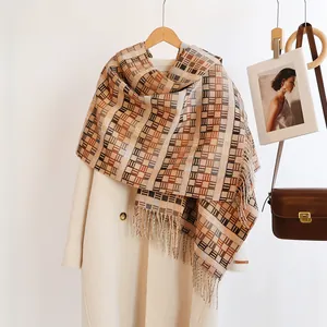 Detail of plaid scarf tassels and handmade leather tag on beige wool winter coat