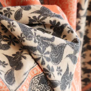 Macro shot of paisley pattern cashmere-like scarf showing soft orange and beige fibers