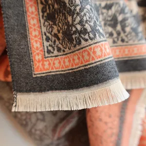 Close-up of cashmere-like shawl featuring paisley patterns and cream white fringe tassels