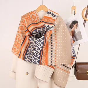 Detail of bohemian Mayan pattern pashmina scarf with vibrant orange geometric motifs