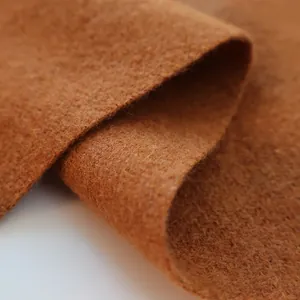 Close-up of soft camel wool scarf fabric showing thick texture and warm fibers