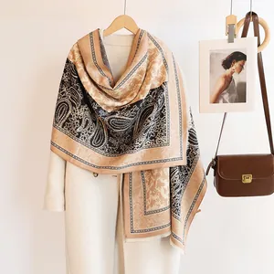 Detail of soft paisley floral cashmere pashmina shawl with fringe on coat