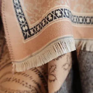 Close-up of pink paisley cashmere scarf with delicate cream-colored fringe detailing