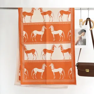 Détail de l'écharpe en cachemire à imprimé équestre orange et beige avec des franges fines