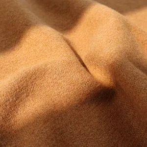 Macro shot of warm camel wool fabric texture with natural soft light and shadow details