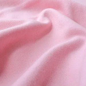 Close-up of soft pink wool scarf fabric showing plush texture and delicate folds