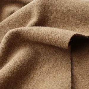 Macro view of tan wool fabric texture showing detailed brushed fibers and soft drapes