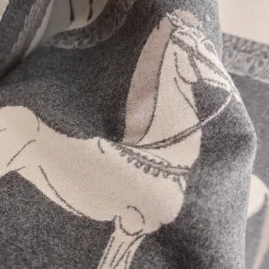 Détail d'une écharpe en cachemire synthétique épais avec motif équestre gris et blanc