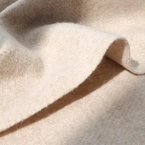 Macro detail of soft beige wool fabric showing thick texture and premium fiber structure