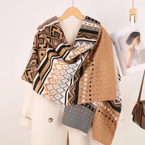 Detailed close-up of geometric Maya pattern scarf with elegant fringe and warm texture