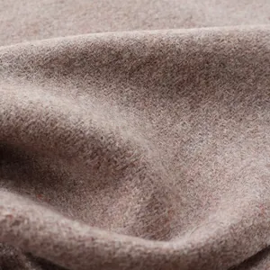 Close-up of soft dusty pink wool fabric texture with warm fine fiber weaving detail