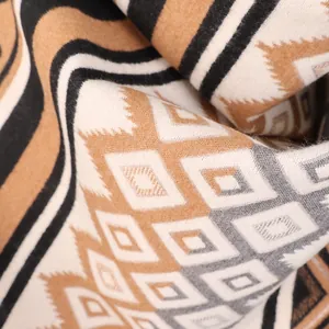 Detailed macro shot of Maya ethnic geometric pattern on warm cashmere-feel shawl fabric