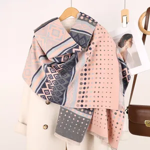 Close-up of pink and grey ethnic geometric shawl with tassel details on a coat