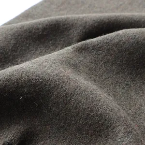 Macro detail of dark brown wool fabric texture with soft brushed fibers and fringe