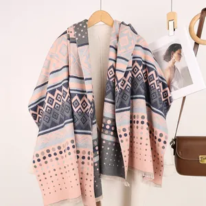 Detail of pashmina shawl with geometric patterns, pink and grey patches and fringes