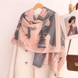 Détail d'une écharpe en cachemire synthétique rose et gris avec motif de cheval