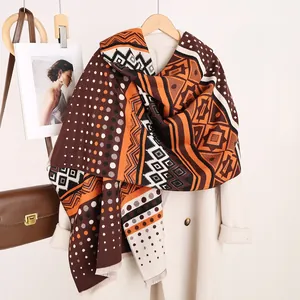 Detail of Mayan geometric cashmere-feel shawl with elegant tassels and warm autumn colors