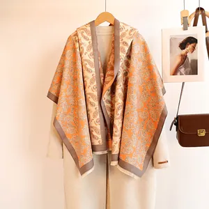 Detail of vintage paisley pattern on warm orange cashmere shawl with fringed edges