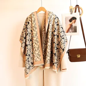 Close-up of beige cashmere shawl with brown paisley patterns and fringe details