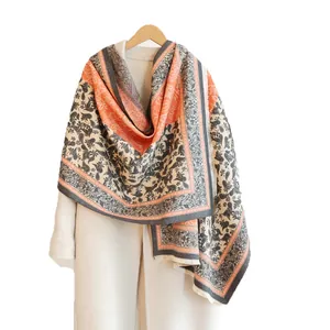 Luxurious cashmere-feel scarf with paisley patterns and tassels on a wool coat