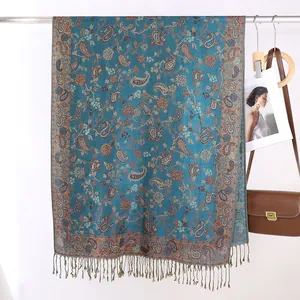 Dettaglio della sciarpa pashmina blu navy con motivo paisley e frange con nappe